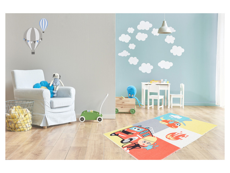 Un tapis de jeu avec une voiture de pompiers, un hélicoptère et des flammes.