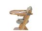 Chaise haute bébé en bois avec rembourrage clair et plateau, vue latérale.