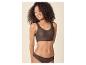 Femme souriante aux cheveux bouclés, portant un soutien-gorge et une culotte marron sans couture.
