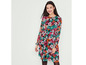 Femme portant une longue robe noire à fleurs.