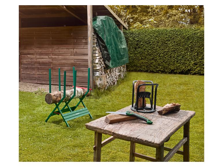 Outils de travail du bois: tréteau de sciage, fendeur de bûches et scie à main sur l'herbe devant un abri.