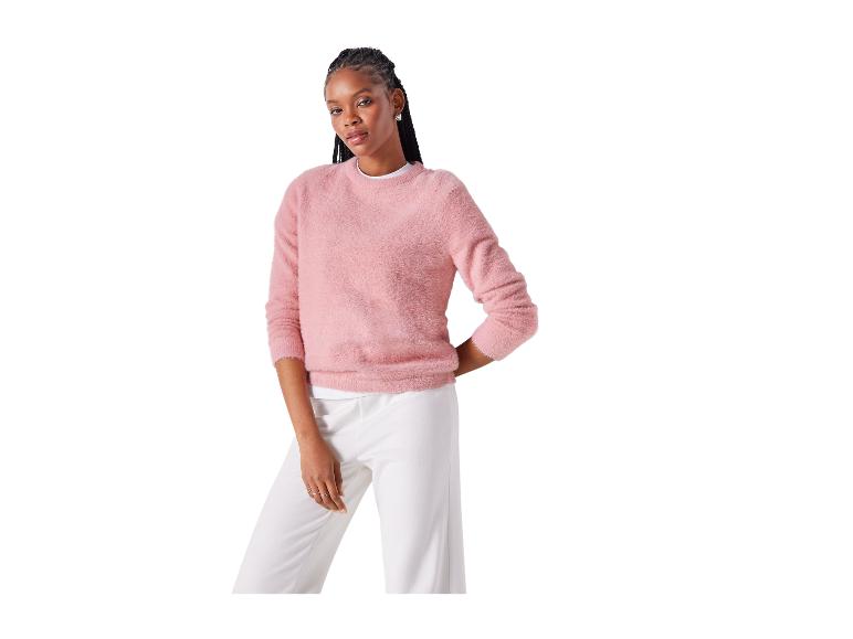 Femme en pull rose duveteux et pantalon blanc