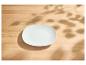 Assiette blanche vide sur une table en bois avec des ombres de feuilles