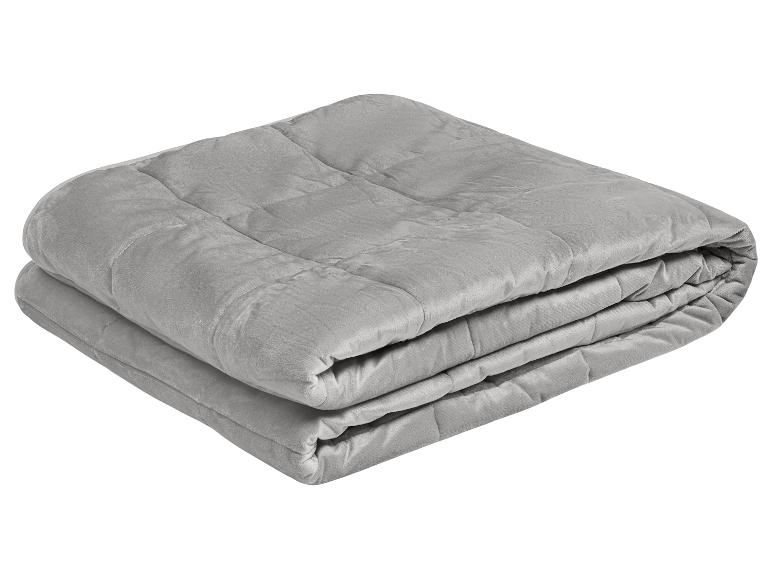 Couverture lestée grise pliée avec motif matelassé.