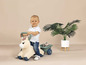 Un enfant chevauche un cheval en bois avec une remorque.