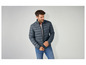 Un homme porte une veste matelassée bleu foncé.