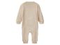 Grenouillère bébé beige à manches longues et pieds fermés.