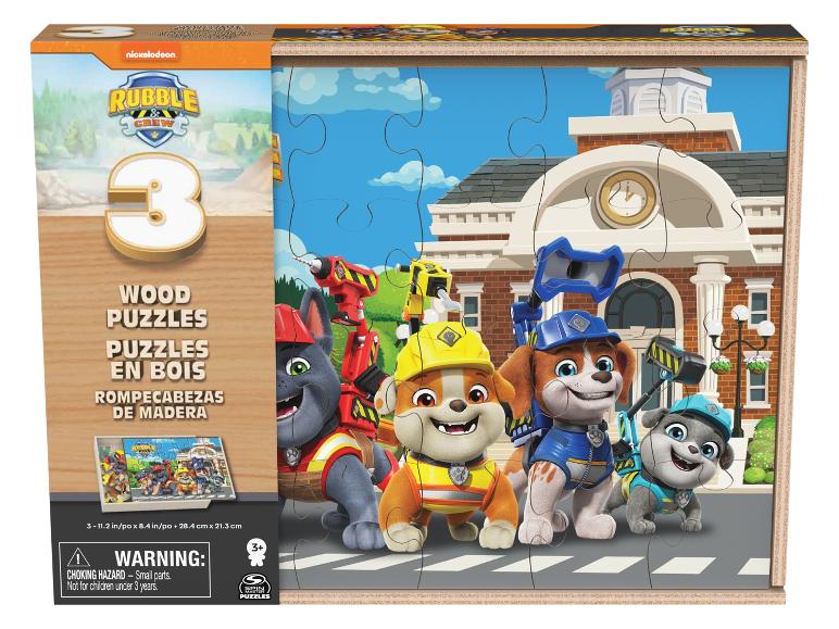 Puzzles en bois représentant trois chiots de dessin animé et un hôtel de ville en arrière-plan.
