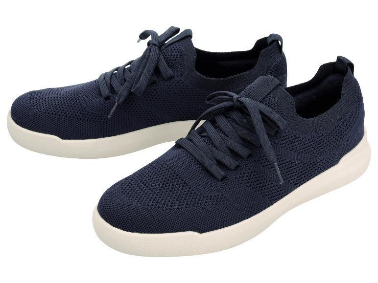 Une paire de chaussures de sport tricotées bleu marine avec des semelles blanches.