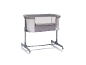 Lit bébé gris avec parois en maille et roulettes