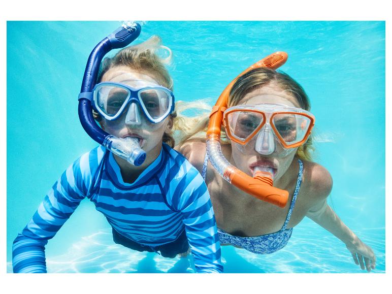 Deux enfants faisant de la plongée avec tuba sous l'eau, portant des t-shirts de bain et des bikinis.