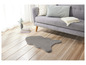 Un tapis gris en fourrure devant un canapé gris