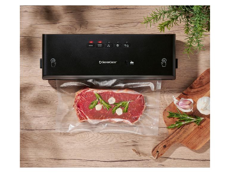 Appareil de mise sous vide SilverCrest avec un morceau de bœuf emballé sous vide, ail et romarin.