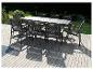 Une table à manger noire avec des chaises sur une terrasse en bois.