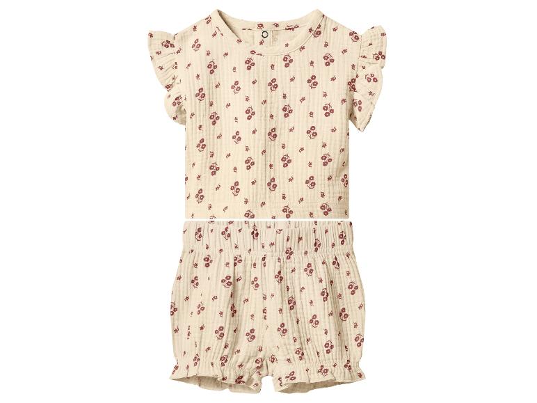 Ensemble bébé deux pièces à motif floral, comprenant un haut à manches volantées et un short assorti.
