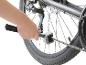 Nettoyage de chaîne de vélo avec une brosse.