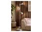 Lampadaire blanc à trois spots réglables à côté d'un canapé beige et de panneaux muraux en bois.