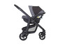 Une poussette Graco noire avec un siège auto.