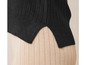Un haut en maille noir sur un pantalon beige côtelé.
