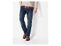 Jeans bleu marine pour homme avec des bottines marron.