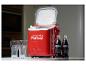 Une glacière Coca-Cola rouge avec deux bouteilles de Coca-Cola et deux verres.