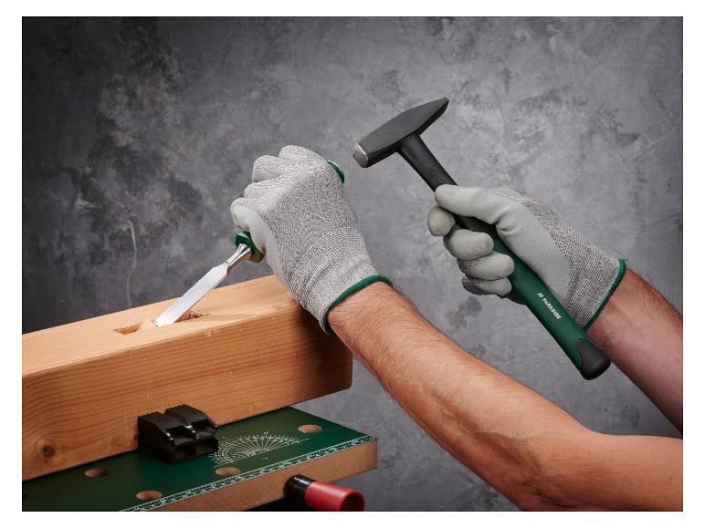 Homme utilisant un ciseau et un marteau Parkside pour travailler le bois sur un établi.