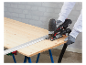 Une personne utilise une scie sauteuse Parkside pour couper du bois sur une table de travail.