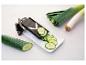 Mandoline pour trancher concombres et poireaux sur fond blanc.
