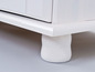 Armoire en bois blanc avec des pieds tournés.