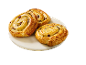 Trois pains aux raisins dorés sur une assiette en marbre blanc