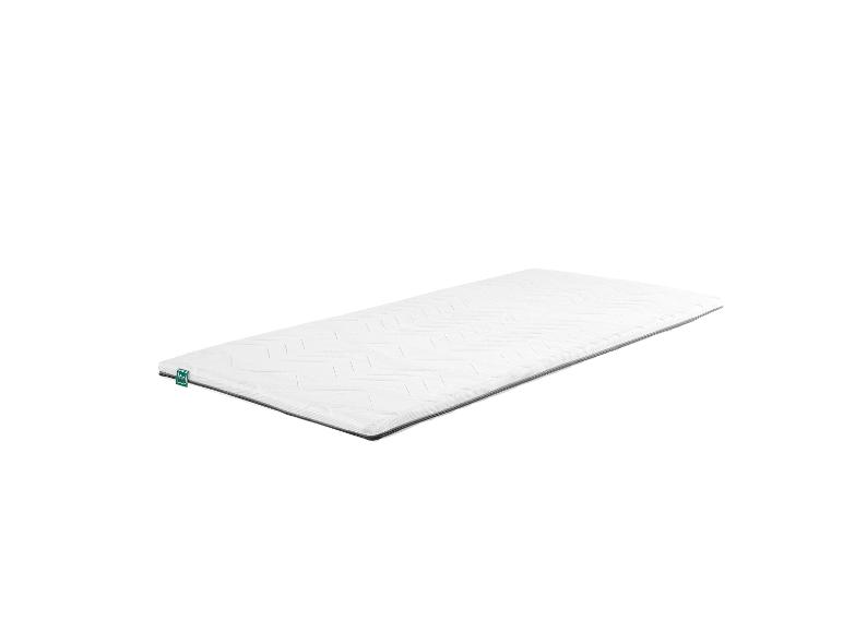 Surmatelas blanc avec motif matelassé et étiquette verte « fan ».