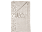 Couverture beige avec motif géométrique de cercles et pompons.