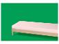Matelas rose sur un cadre de lit en bois sur fond vert.