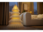Lampadaire décoratif en forme de sapin de Noël lumineux dans un salon chaleureux.