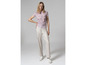 Femme portant un t-shirt à imprimé et un pantalon blanc.