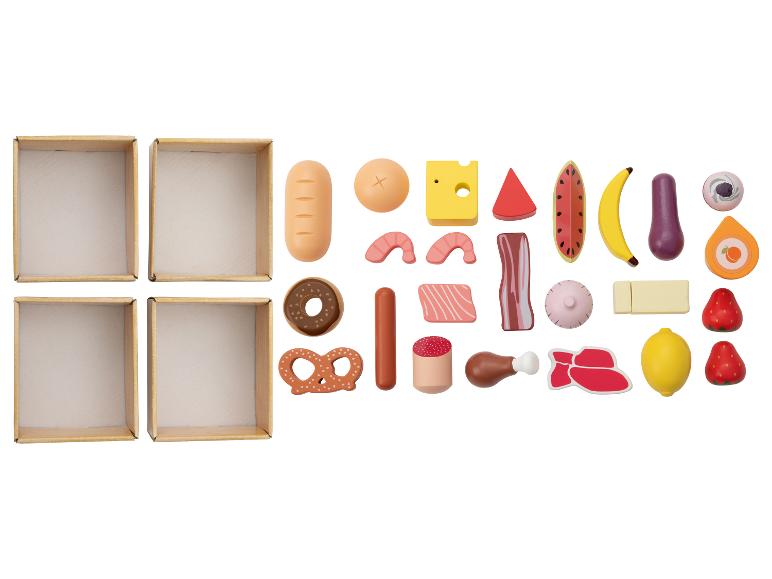 Boîtes vides et une variété d'aliments jouets, y compris du pain, des fruits, de la viande et des bonbons.