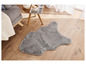 Un tapis gris en fourrure synthétique en forme de nuage sur un sol en bois.