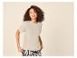 Femme en t-shirt beige à manches courtes et pantalon à motifs noir et blanc.