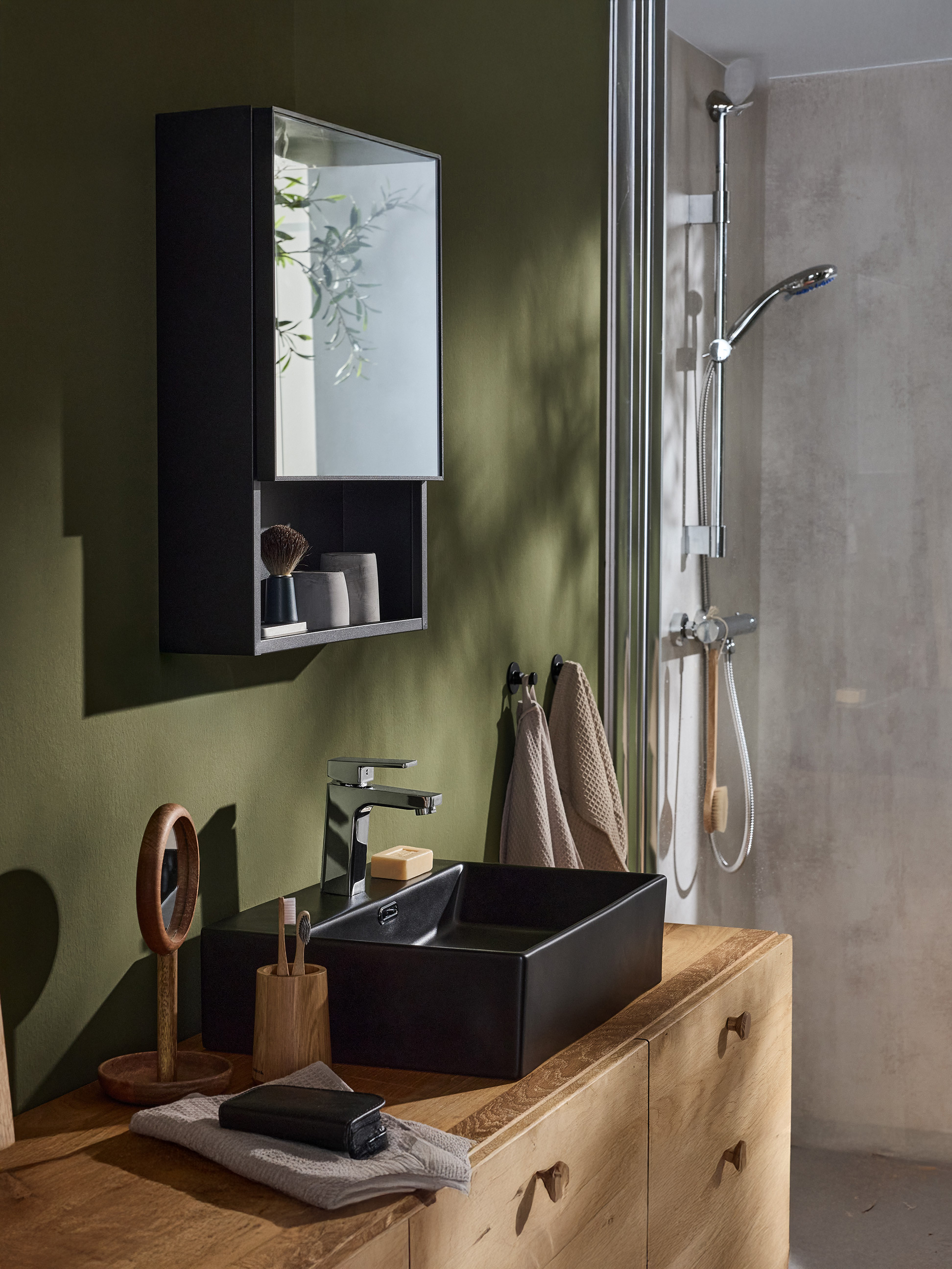 Une salle de bain moderne avec une armoire noire, un lavabo noir, un robinet chromé et une douche.