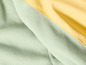 Gros plan sur un tissu polaire doux, vert clair, avec une couche extérieure jaune.