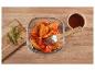 Ailes de poulet marinées au romarin et sauce barbecue dans un bol en verre.
