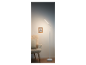 Lampe sur pied LED blanche moderne à côté d'un fauteuil.