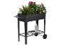 Jardinière surélevée noire à roulettes, remplie de plantes et d'outils de jardinage.