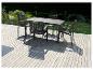 Une table à manger noire avec quatre chaises assorties sur une terrasse en bois.
