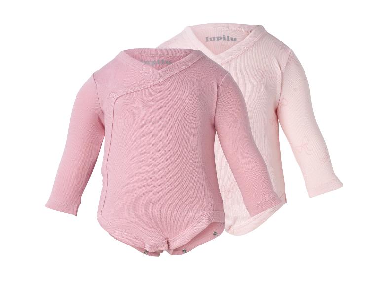 Deux bodys bébé roses à manches longues, un uni et un avec un motif de nœuds.
