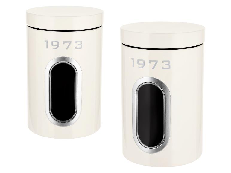 Deux boîtes de conserve crème avec le texte '1973' et une fenêtre pour voir le contenu.