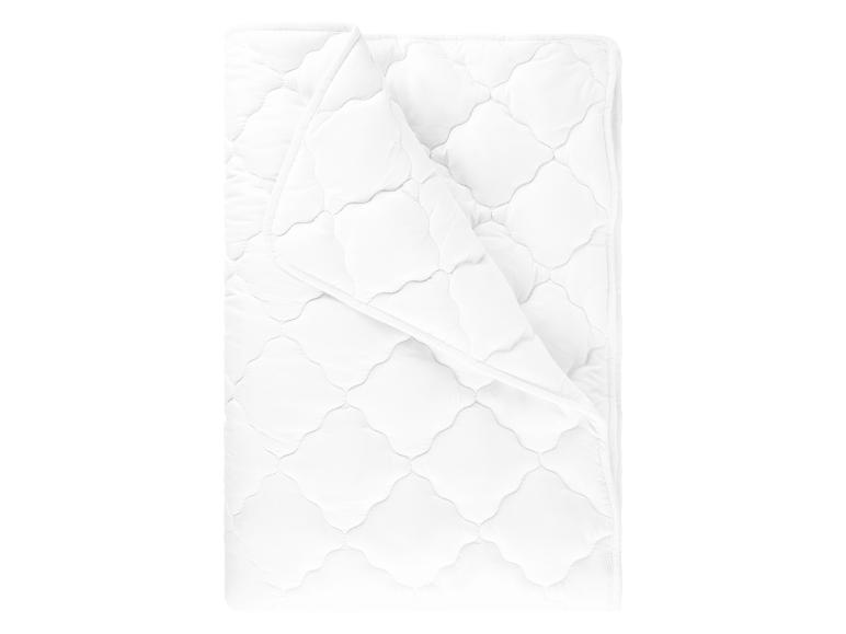 Une couette blanche avec un motif matelassé.