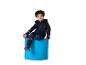 Enfant assis sur un tabouret bleu, portant une combinaison bleu foncé avec des bandes réfléchissantes.