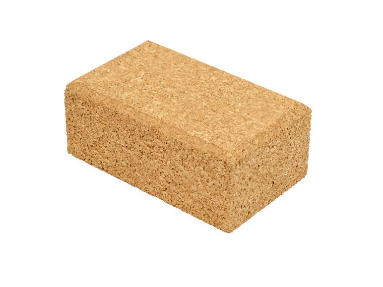 Un bloc de yoga rectangulaire en liège, marron clair avec une surface texturée, isolé sur blanc.