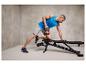 Un homme s'entraîne avec une kettlebell sur un banc de musculation ajustable.